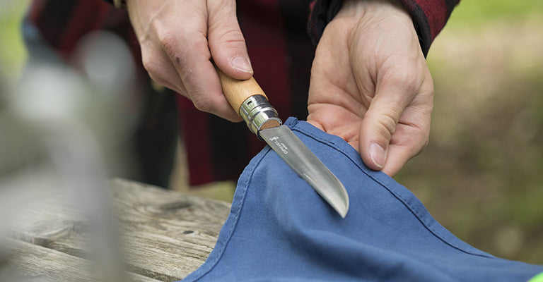 Uomo che asciuga coltello opinel su panno azzurro 